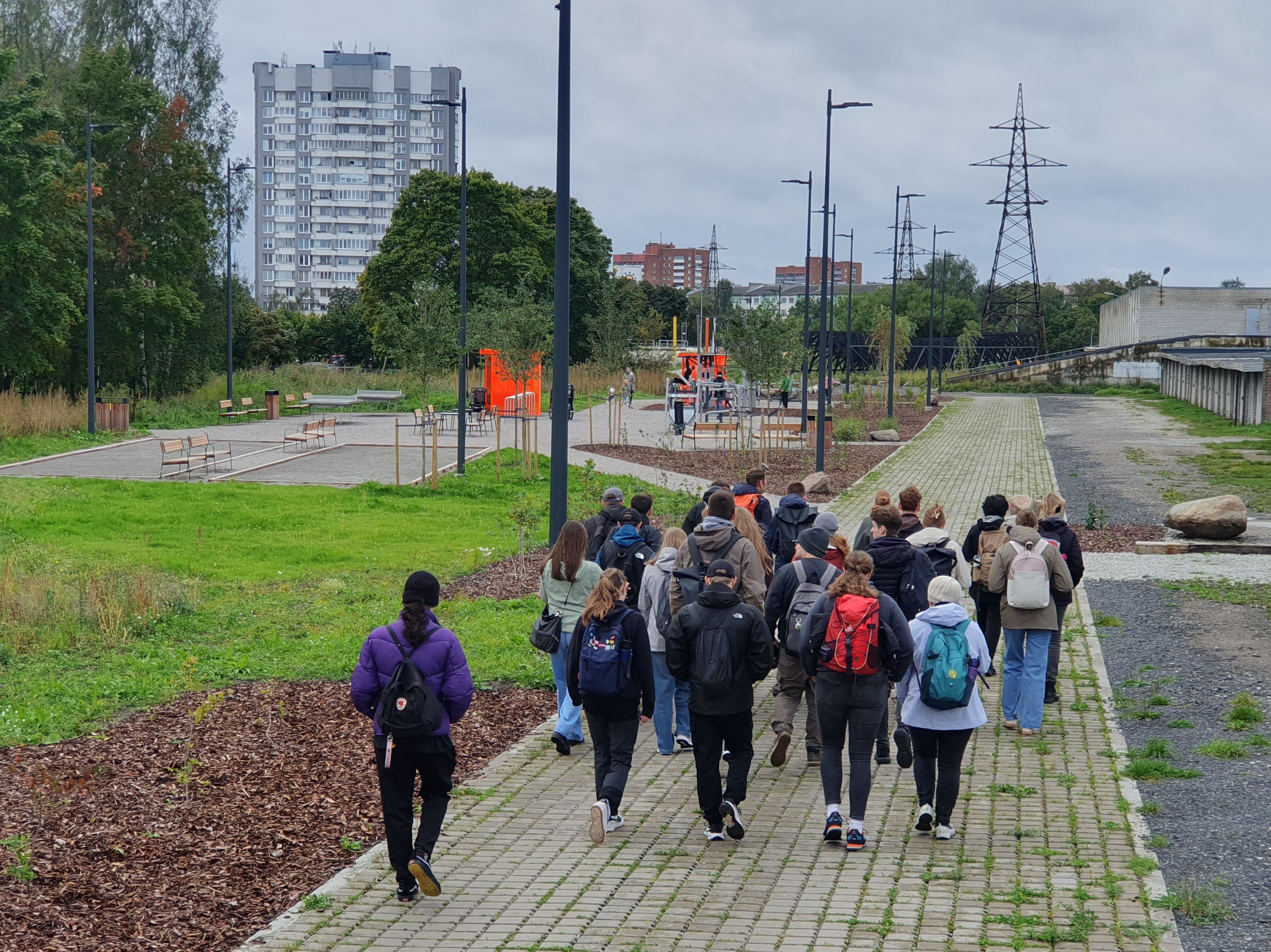 Das Bild zeigt eine Gruppe Studierender, die durch eine Vorstadt laufen